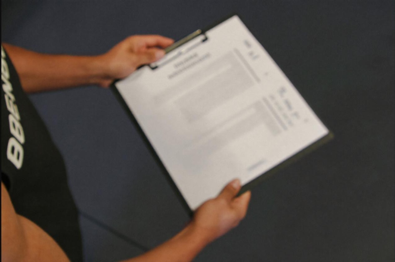 Coach and athlete reviewing a training plan on a clipboard