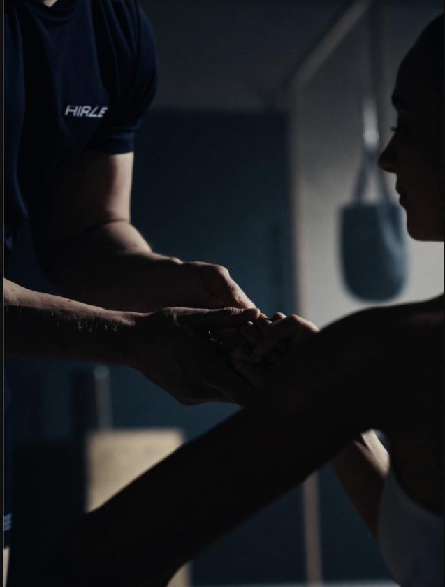 Close-up of a performance coach guiding an athlete through a strength session