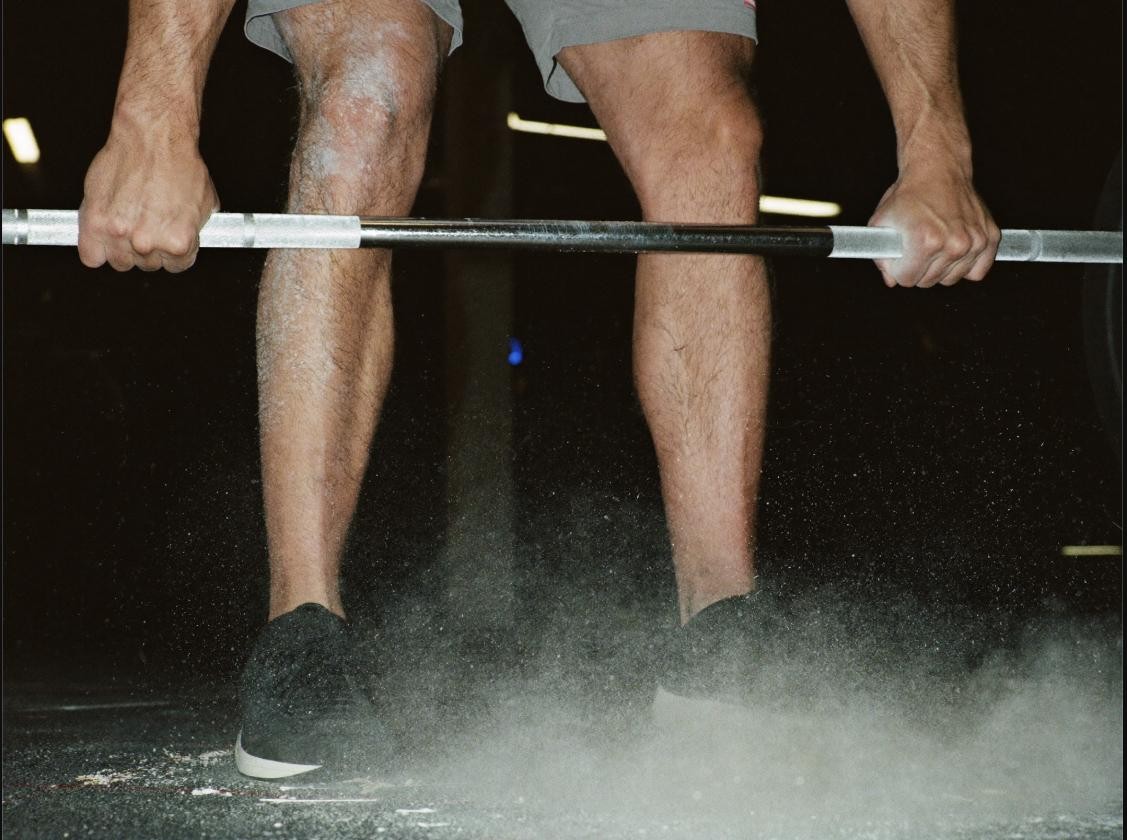 Close-up of an athlete's legs mid barbell deadlift